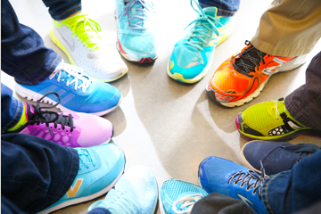 A circle of people wearing many colored sneakers